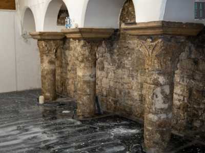 L�interno per� svela una struttura ancora pi� antica, sicuramente di epoca medievale. Sulla destra infatti si stagliano tre grigie colonne in pietra che terminano con eleganti capitelli decorati che reggono una serie di quattro archetti centinati